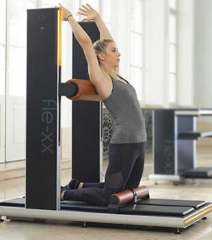 Frau beim Dehnen auf Fitnessgerät