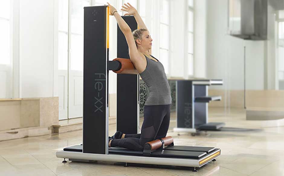 Frau beim Dehnen auf Fitnessgerät