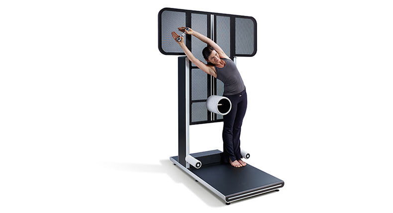 Frau dehnt sich an Fitnessgerät